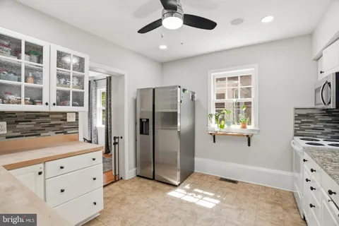 a kitchen with granite countertop white cabinets stainless steel appliances and a window