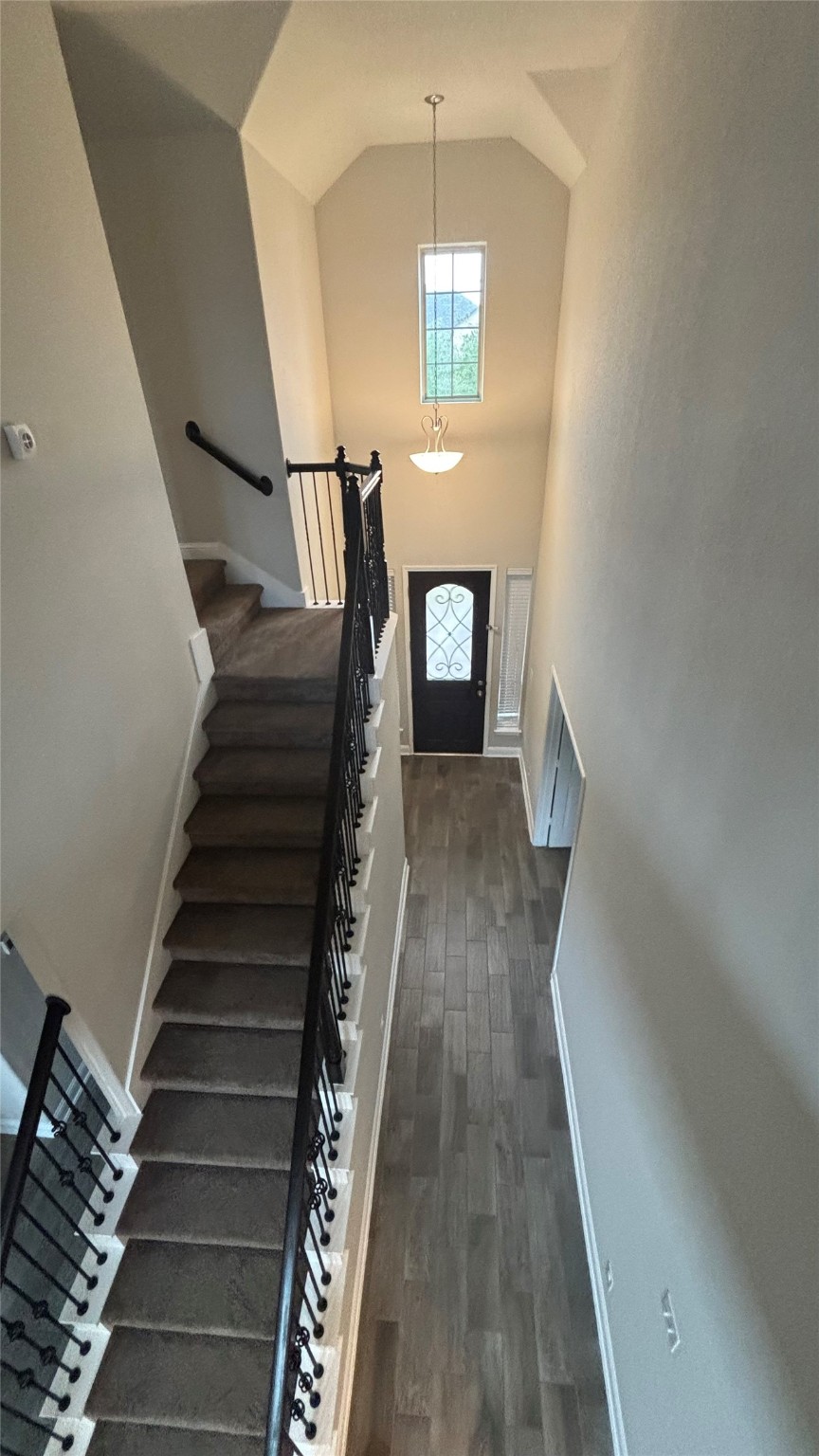 14915 Gyrfalcon Fork Cypress, TX 77429 - Photo 14 of 24 Elegant staircase with wrought iron railings leads to a bright, airy upstairs, featuring a stunning window view.
