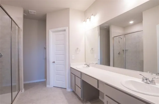 a bathroom with a double vanity sink a mirror and a shower