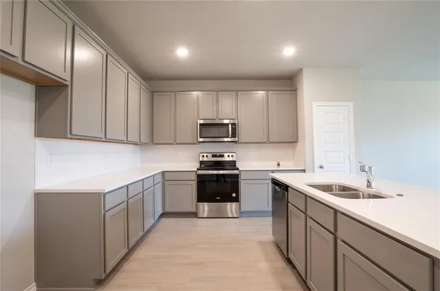a kitchen with a sink stove and microwave