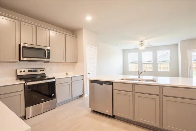a kitchen with a sink stove and microwave