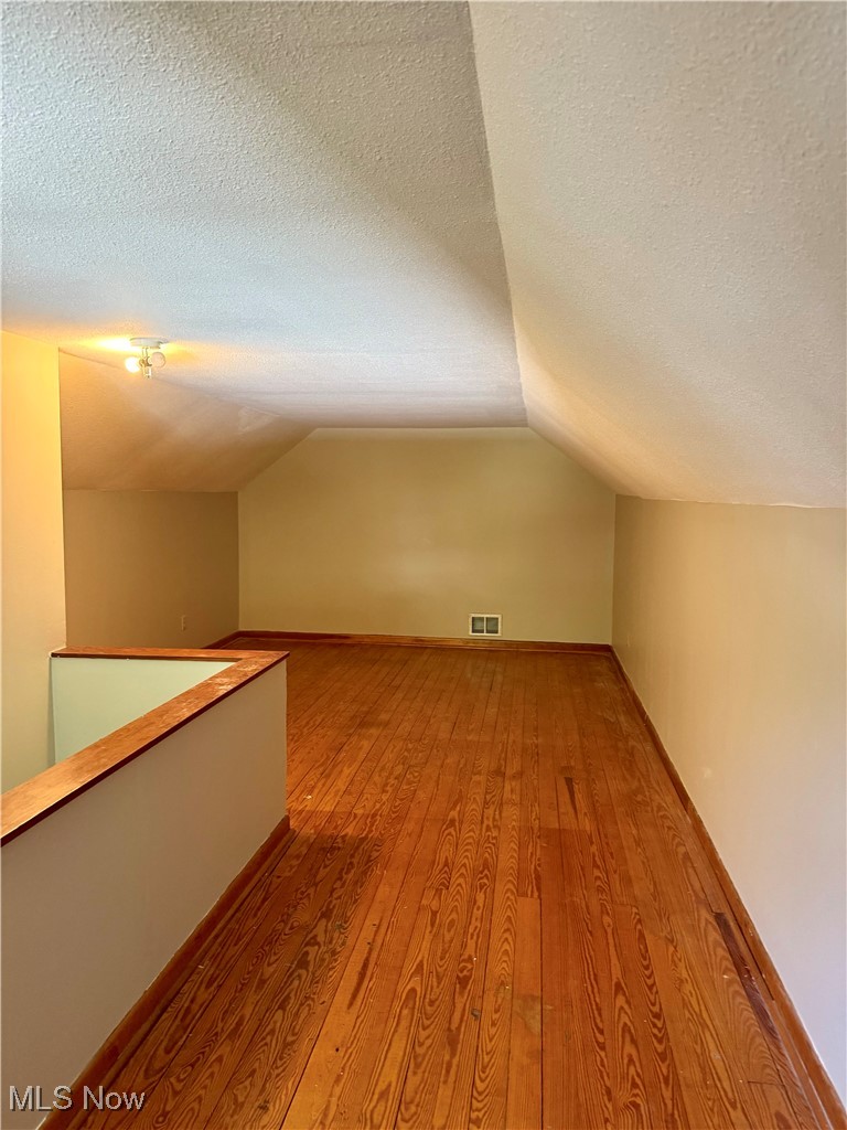 1655 Spring Street Coshocton, OH 43812 - Photo 18 of 19 Bonus room featuring a textured ceiling, light hardwood / wood-style flooring, and vaulted ceiling