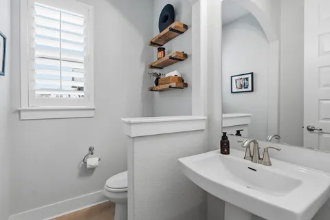 a bathroom with a sink a toilet and a window