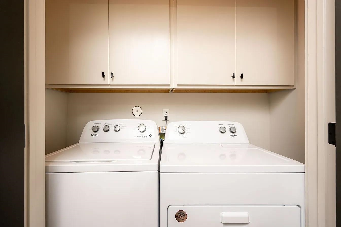 752 Meda Street Memphis, TN 38104 - Photo 16 of 18 Dedicated laundry area featuring overhead cabinetry with dark hardware and a wood-finish shelf