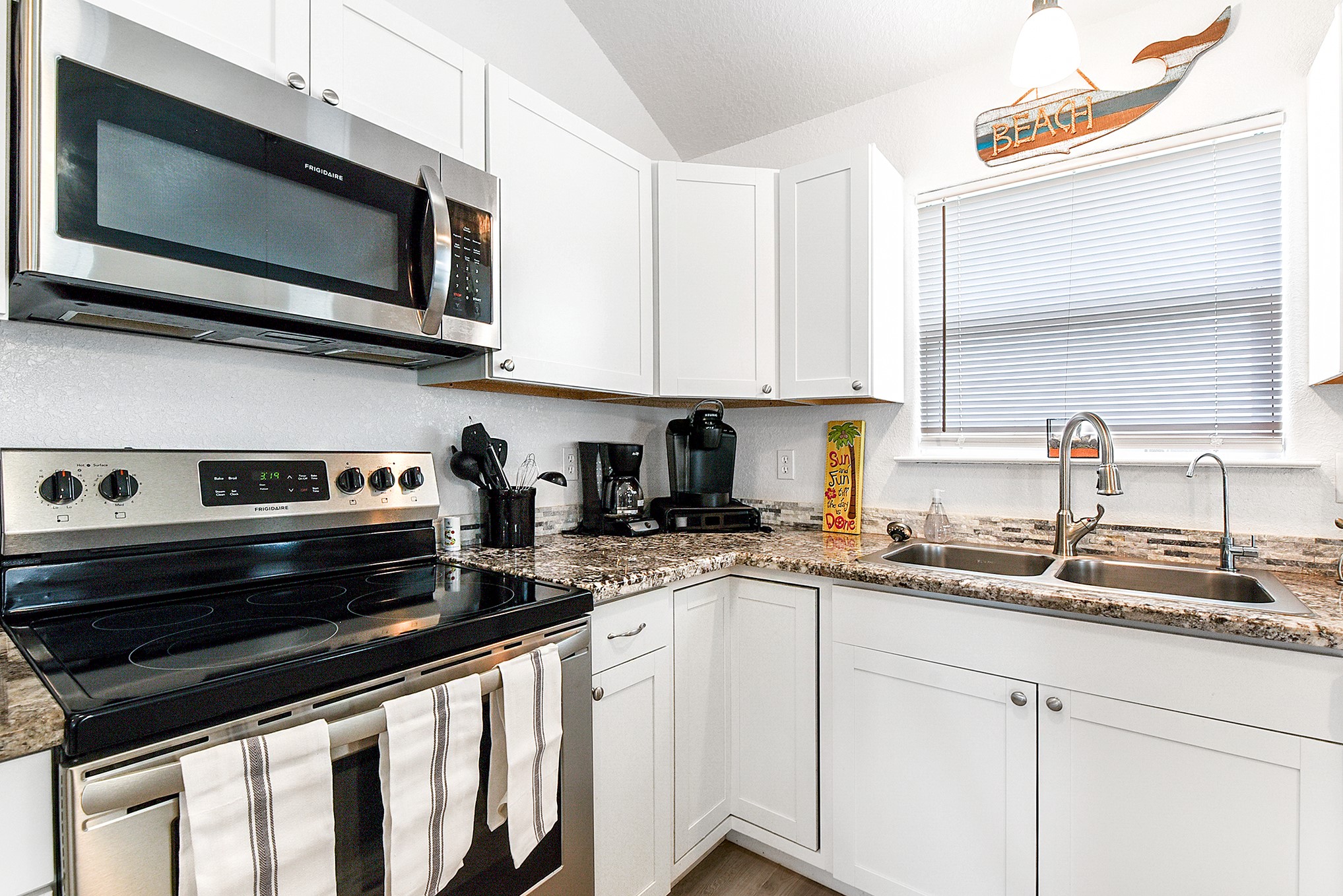 126 Nesmith Place Surfside Beach, TX 77541 - Photo 27 of 48 a kitchen with stainless steel appliances a stove a microwave a sink and cabinets