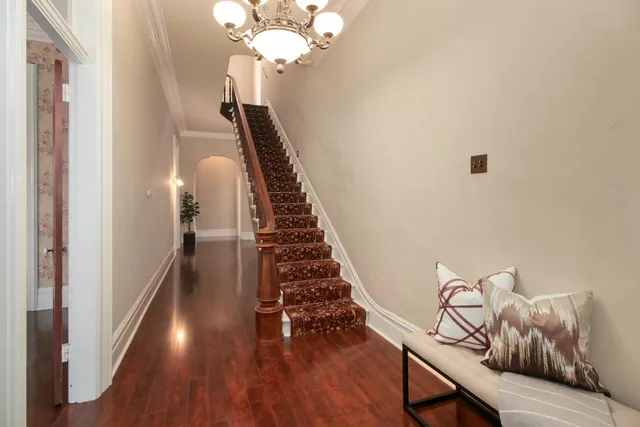 a view of a hallway with wooden floor and staircase