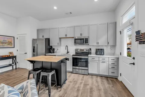 a kitchen with white cabinets stainless steel appliances and white appliances