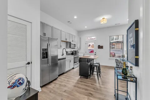 a kitchen that has a lot of cabinets a sink and appliances in it