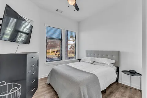 a bedroom with a large bed and a flat tv screen on dresser