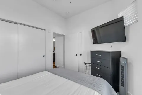 a bedroom with a bed and a flat screen tv