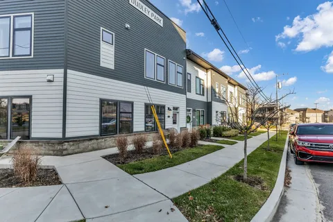 a front view of a building with parked cars