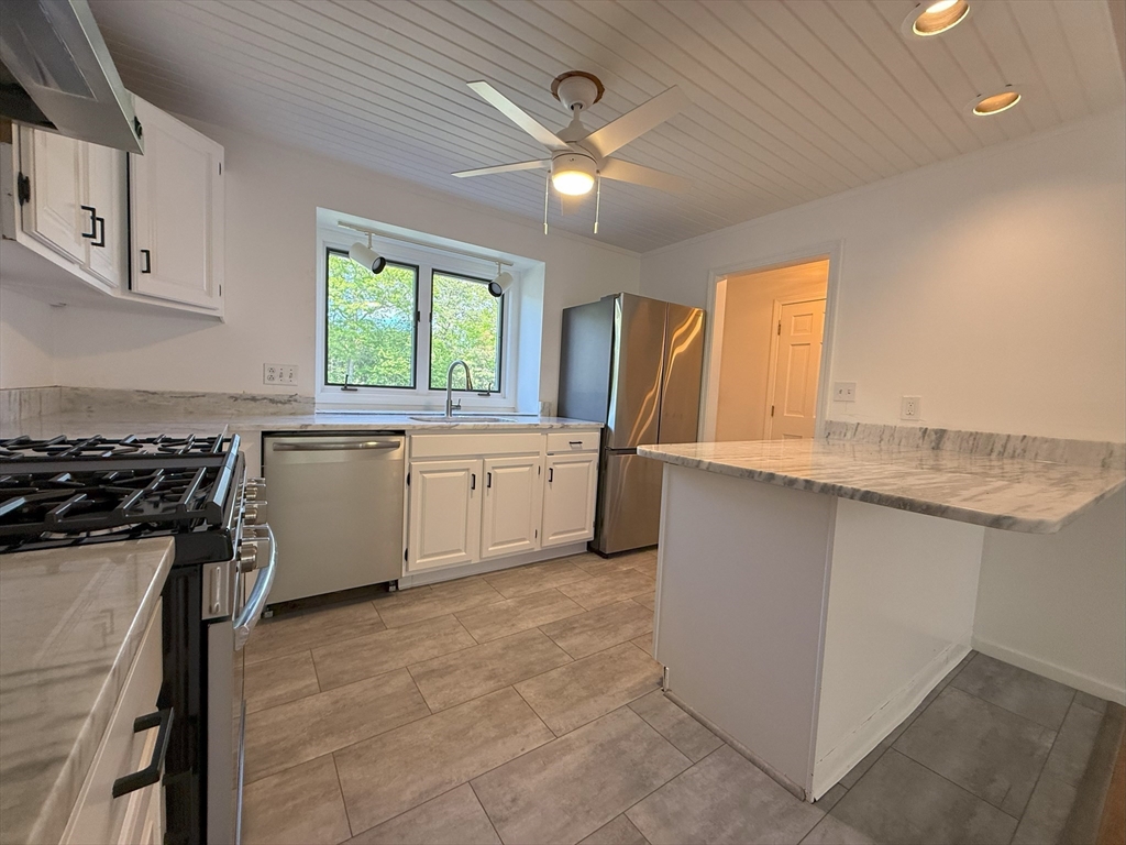 51 A Minot Avenue, Unit 1 Wareham, MA 02571 - Photo 4 of 26 a kitchen with a sink stove and cabinets