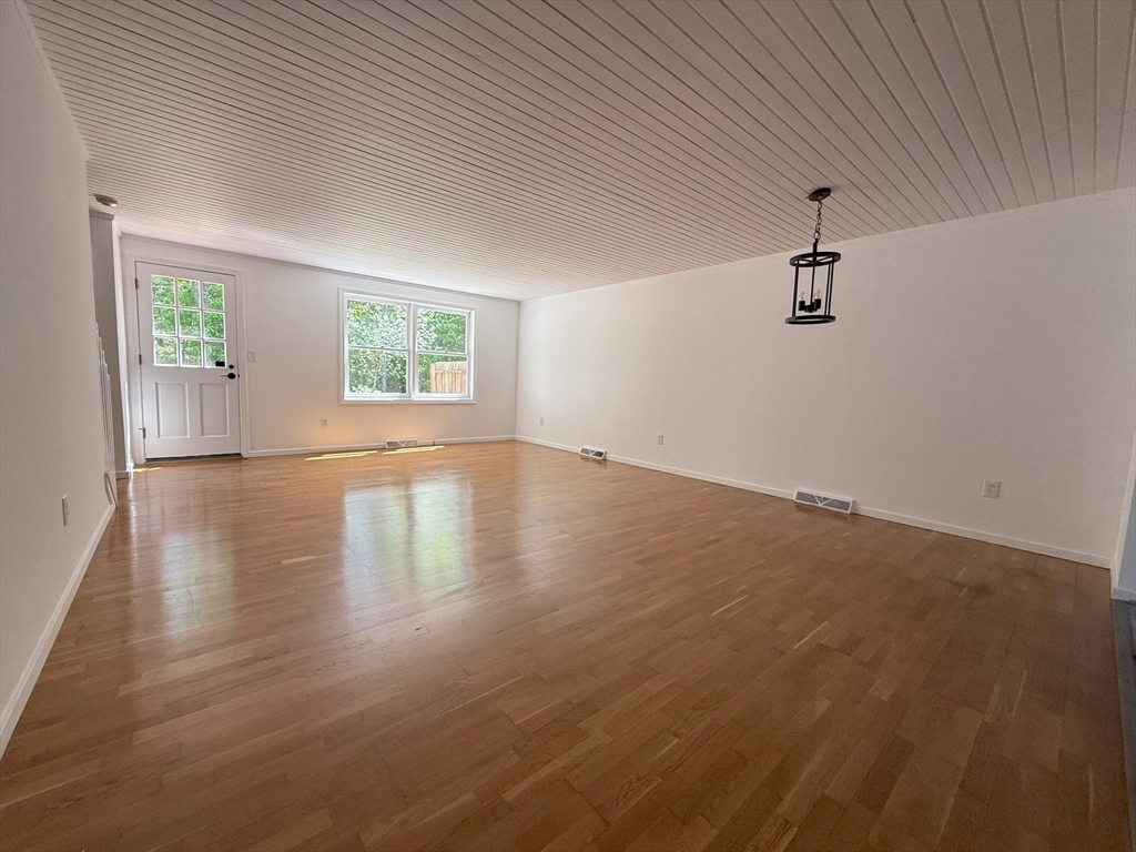 51 A Minot Avenue, Unit 1 Wareham, MA 02571 - Photo 7 of 26 an empty room with wooden floor chandelier fan and windows