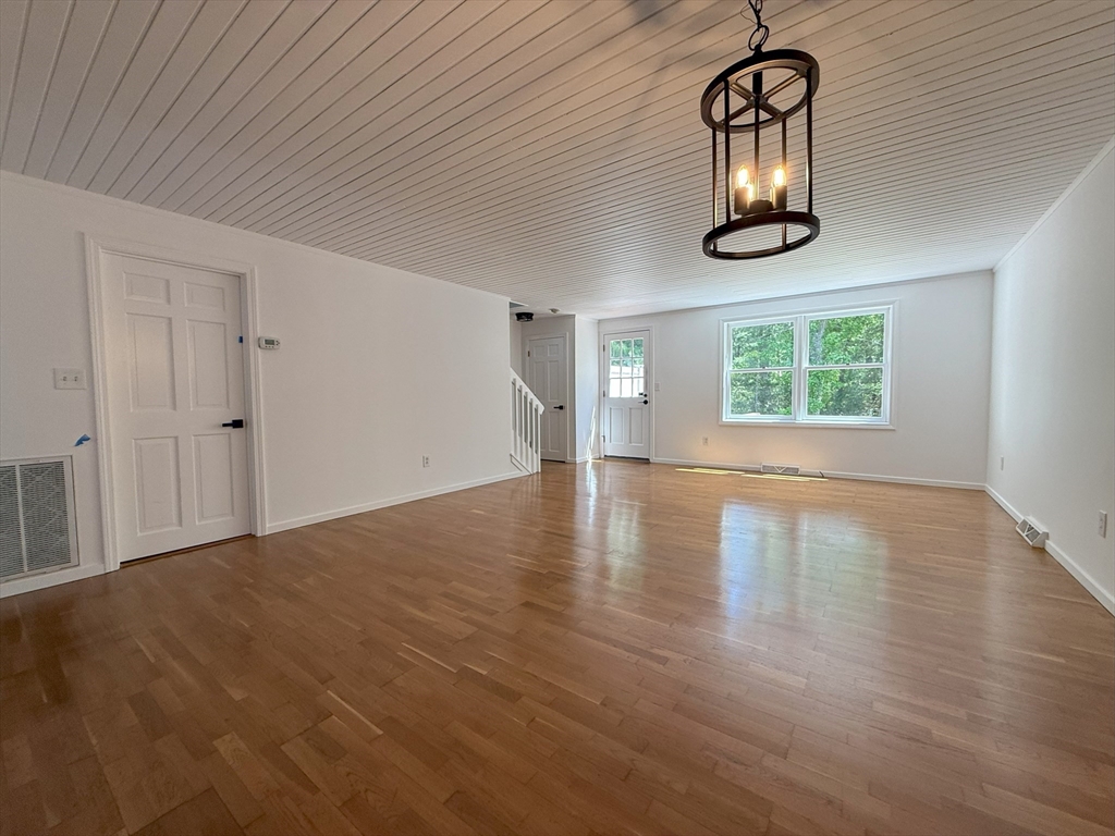 51 A Minot Avenue, Unit 1 Wareham, MA 02571 - Photo 8 of 26 an empty room with wooden floor chandelier and windows