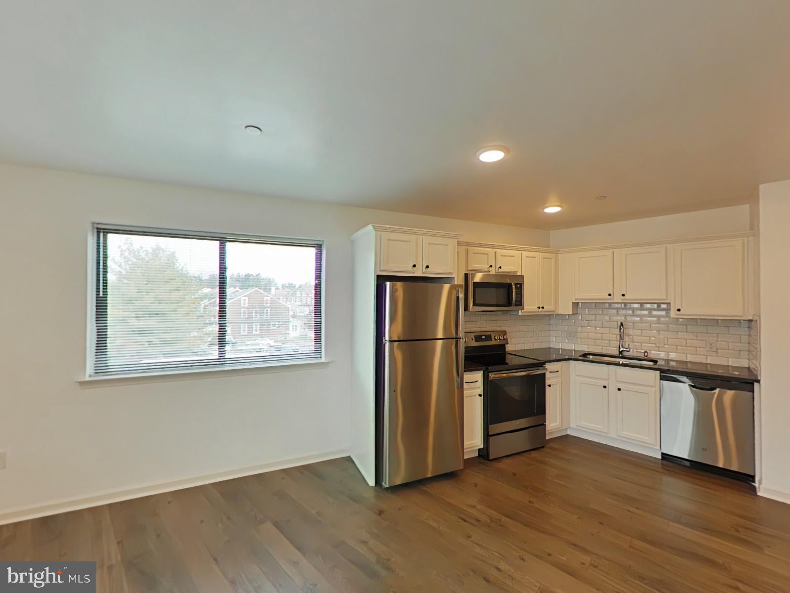 5420 Ridge Avenue, Unit 409 Philadelphia, PA 19128 - Photo 2 of 13 a kitchen with a refrigerator and wooden floor