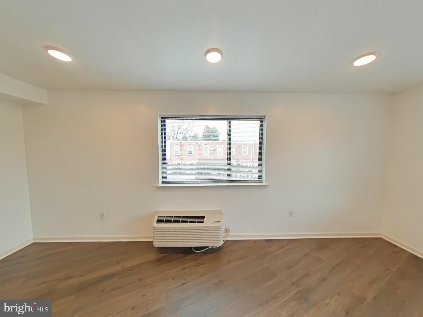 5420 Ridge Avenue, Unit 409 Philadelphia, PA 19128 - Photo 5 of 13 an empty room with wooden floor and windows