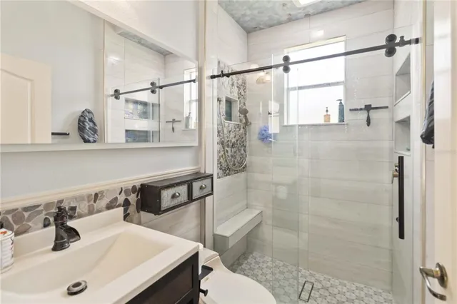 a bathroom with a sink a toilet and shower