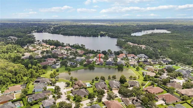 an aerial view of ocean and residential houses with outdoor space