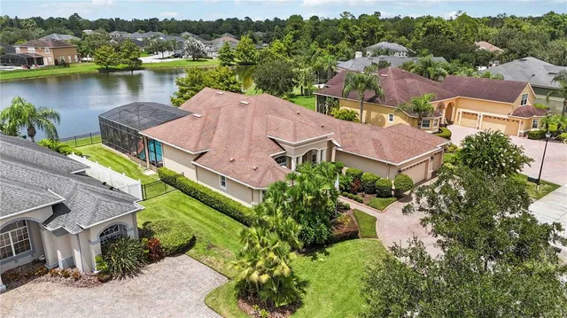 an aerial view of a house with a garden and lake view