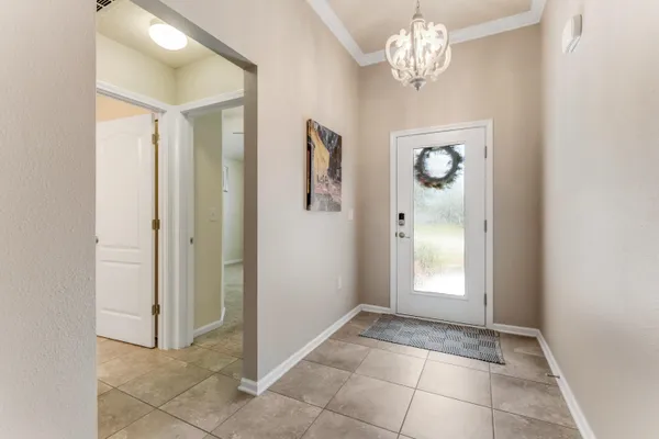 a view of a hallway with windows and chandelier