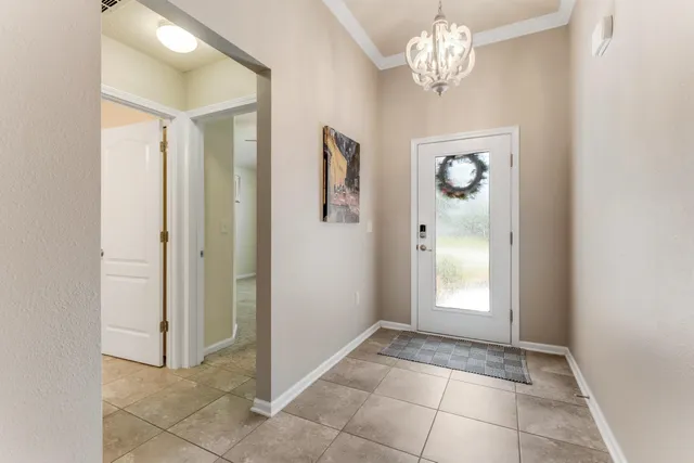 a view of a hallway with windows and chandelier