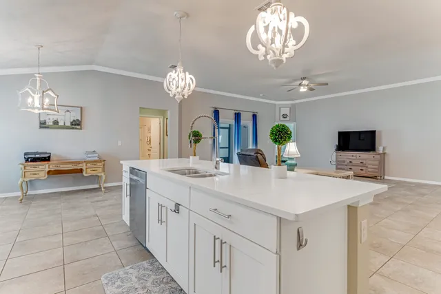a view of living room kitchen with a sink and chandelier