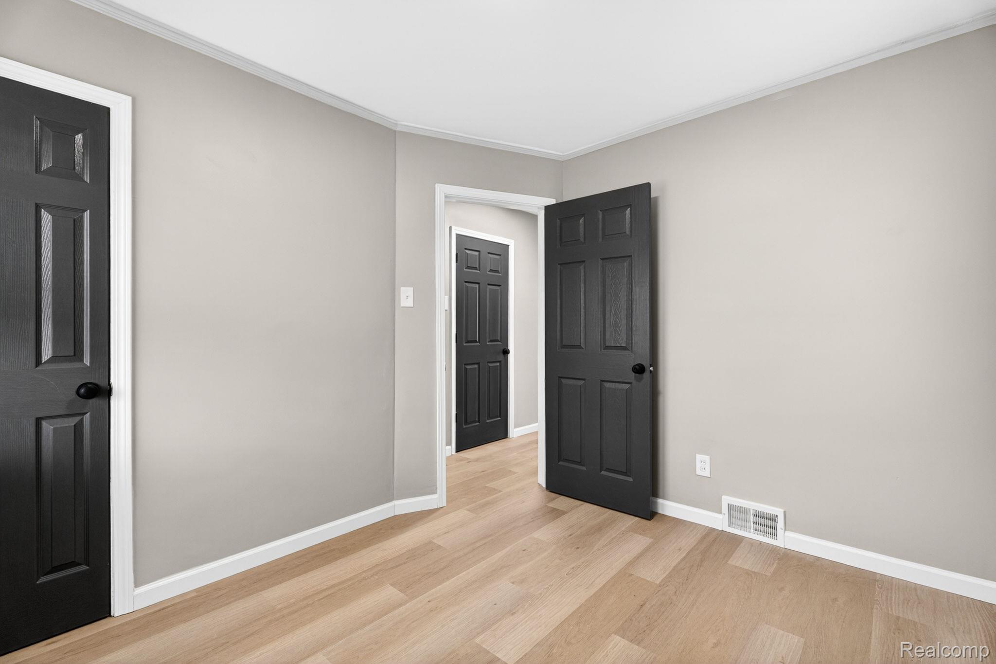 17197 Rutherford Street Detroit, MI 48235 - Photo 11 of 22 Empty room featuring light wood-style flooring and ornamental molding
