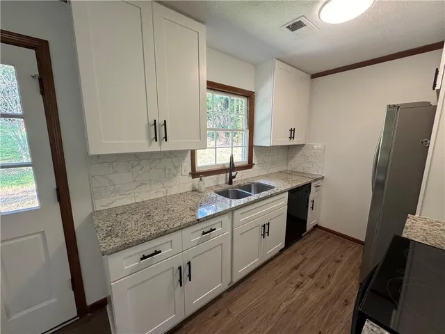 a kitchen with granite countertop a sink stove and refrigerator