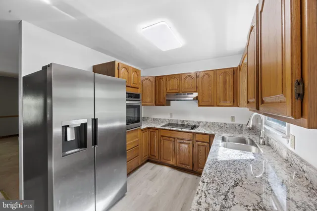 a bathroom with a granite countertop sink and a toilet