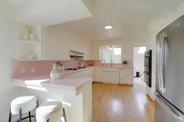 a kitchen with a refrigerator and a stove top oven