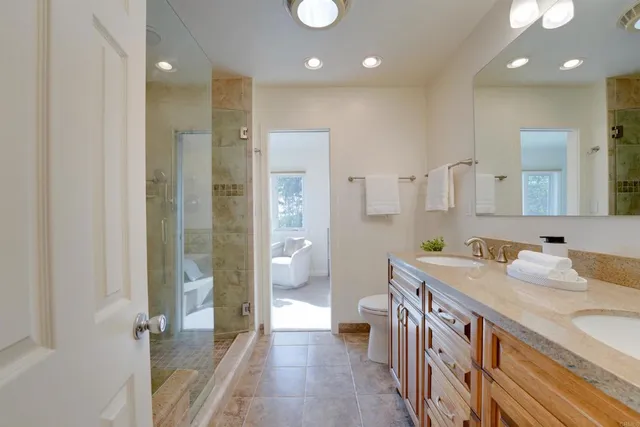 a spacious bathroom with a double vanity sink a large mirror and shower