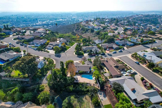 an aerial view of a house with a yard and a large tree