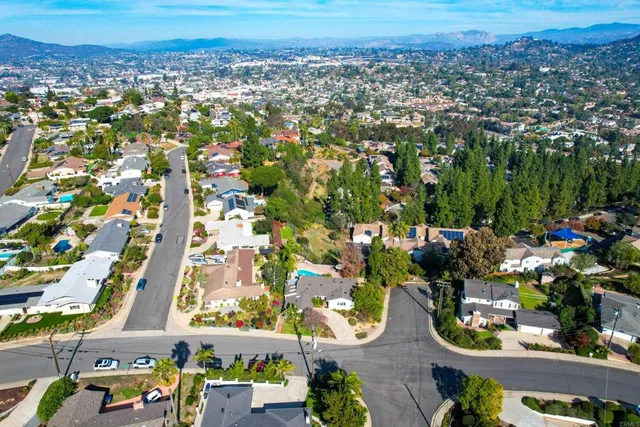 a view of a house with a yard and potted plants