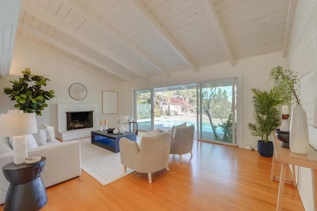 a living room with furniture a fireplace and a large window