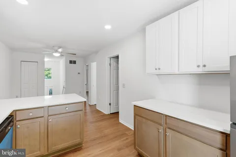 a kitchen with white cabinets and sink