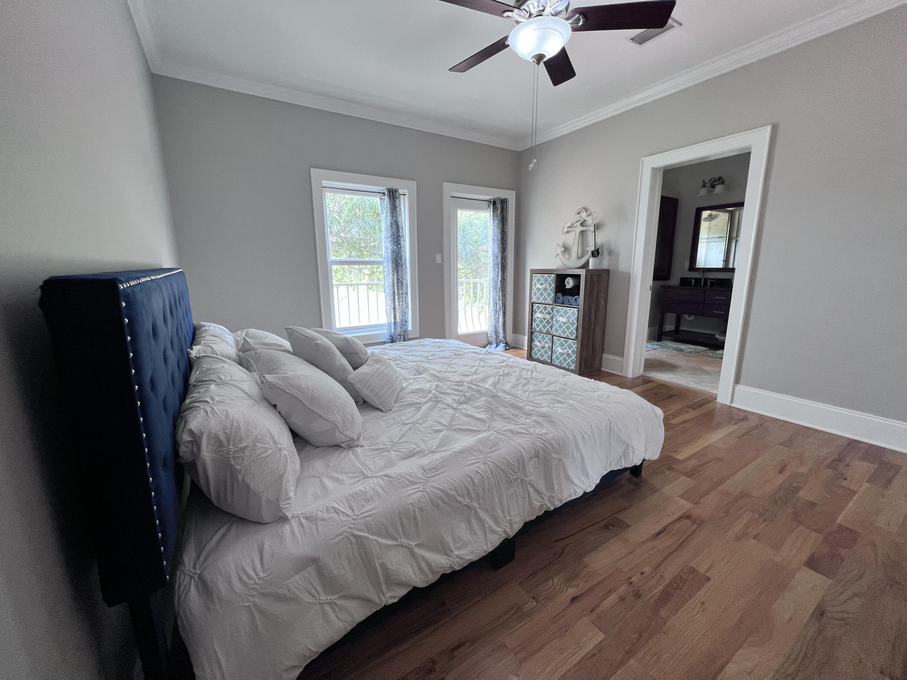 43 Coastal Grove Way, Unit 5 Santa Rosa Beach, FL 32459 - Photo 41 of 56 a large bed sitting in a bedroom next to a window and a chandelier