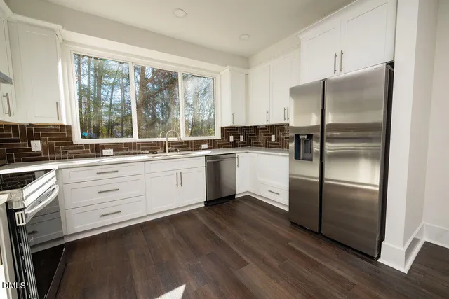 a kitchen with white cabinets and white stainless steel appliances