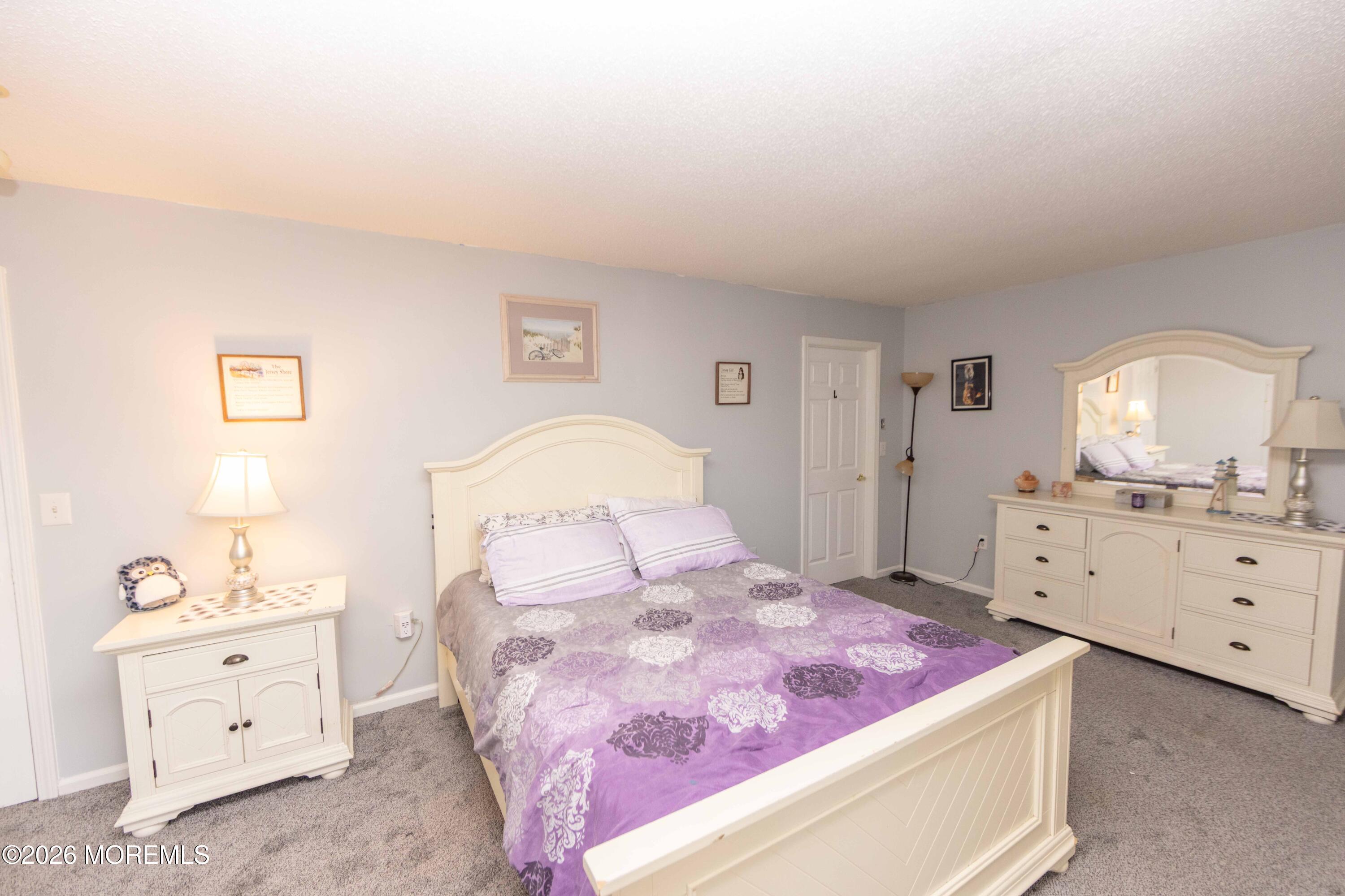 52 Riva Boulevard, Unit 1967 Brick, NJ 08723 - Photo 13 of 15 a spacious bedroom with a bed and a dresser in it