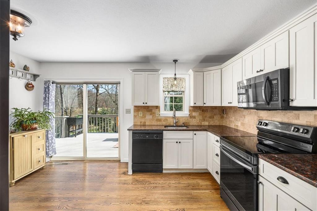 4199 Woodland Road Butler, PA 16002 - Photo 8 of 42 a kitchen with stainless steel appliances granite countertop a stove top oven a sink a counter space and cabinets