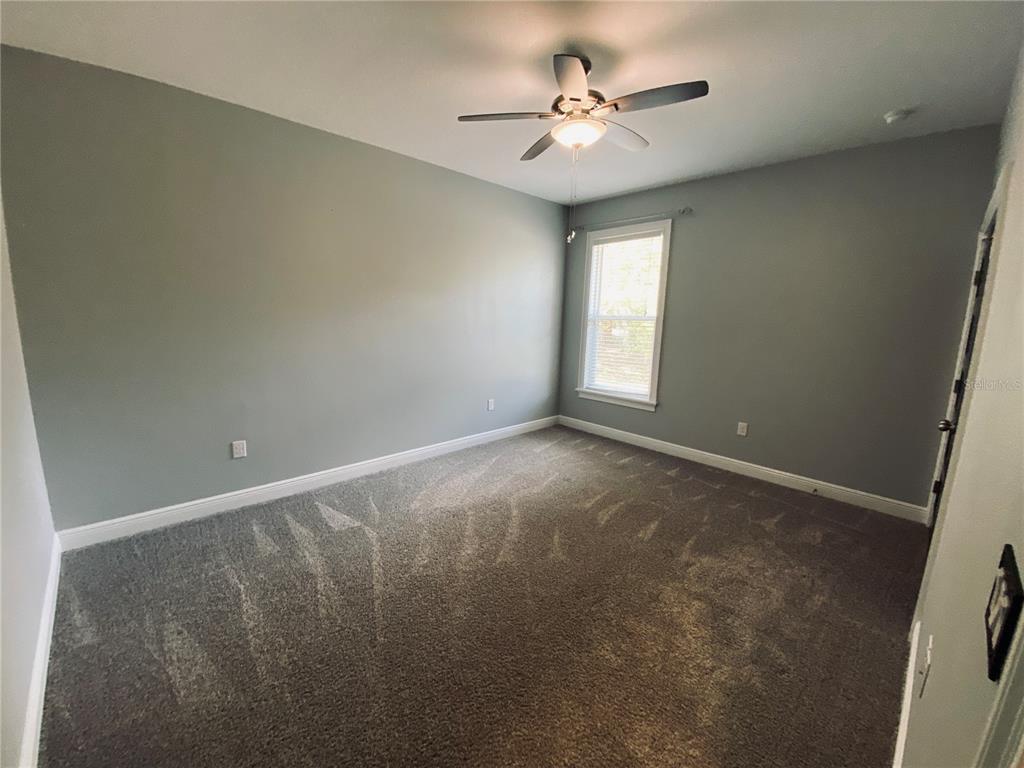 11802 Shadow Run Boulevard Riverview, FL 33569 - Photo 22 of 51 an empty room with a chandelier fan and windows