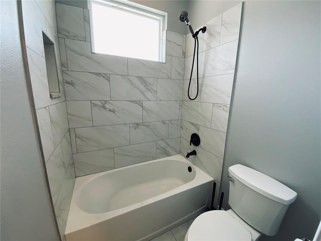 11802 Shadow Run Boulevard Riverview, FL 33569 - Photo 26 of 51 a bathroom with a toilet bathtub window and shower