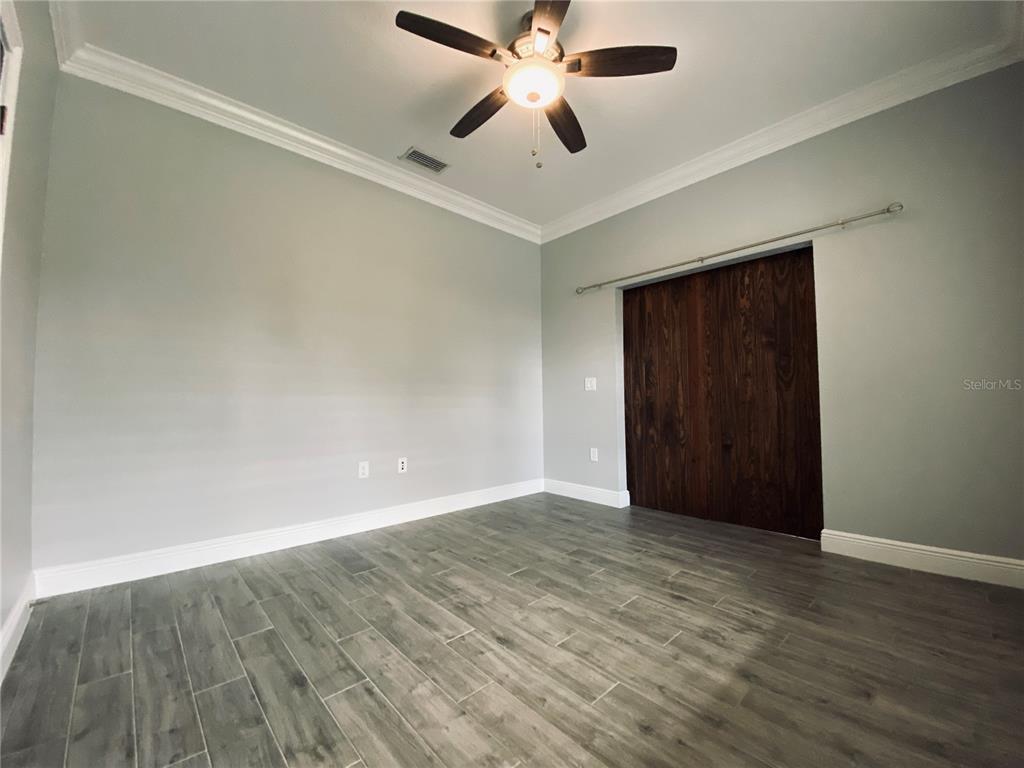 11802 Shadow Run Boulevard Riverview, FL 33569 - Photo 36 of 51 an empty room with wooden floor and ceiling fan