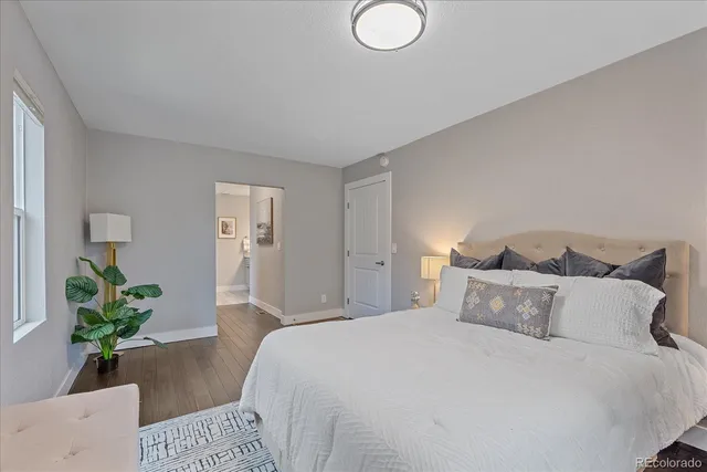 a bedroom with bed and a potted plant