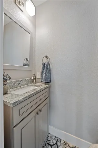 a bathroom with a granite countertop sink and a mirror