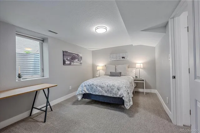 a spacious bedroom with a bed and a table in it