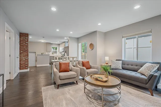 a living room with furniture and a wooden floor