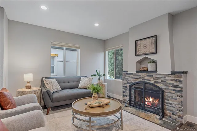 a living room with furniture a fireplace and a window