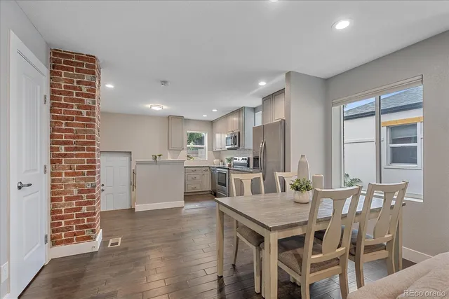 a kitchen with a dining table chairs and refrigerator