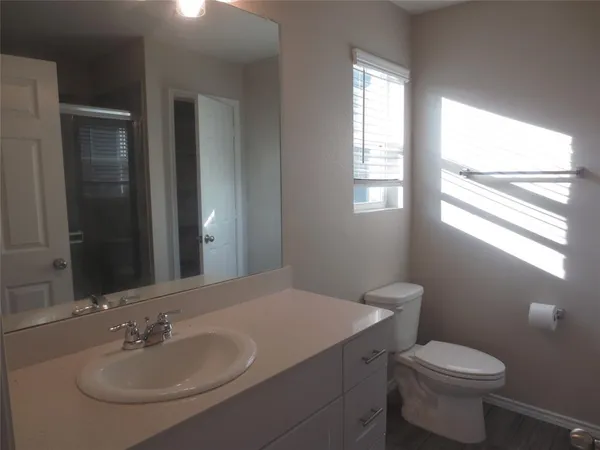 a bathroom with a bathtub shower sink vanity and toilet