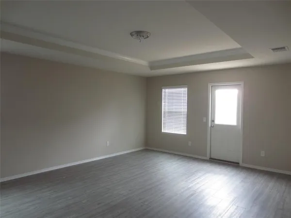 a view of a big room with wooden floor and windows
